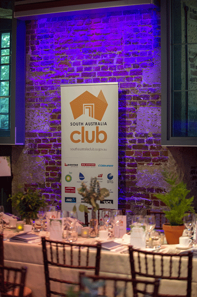 Photo of table at dinner with SA Club banner in background