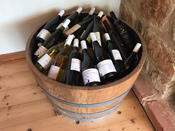 Photo of half wine barrel filled with bottles of wine